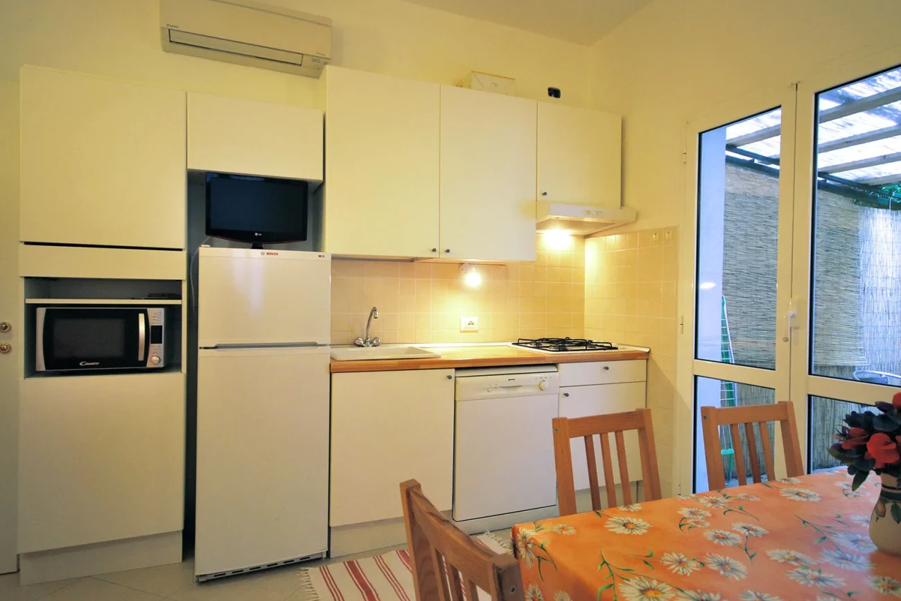 Bilocale H – Soggiorno con cucina e accesso al patio